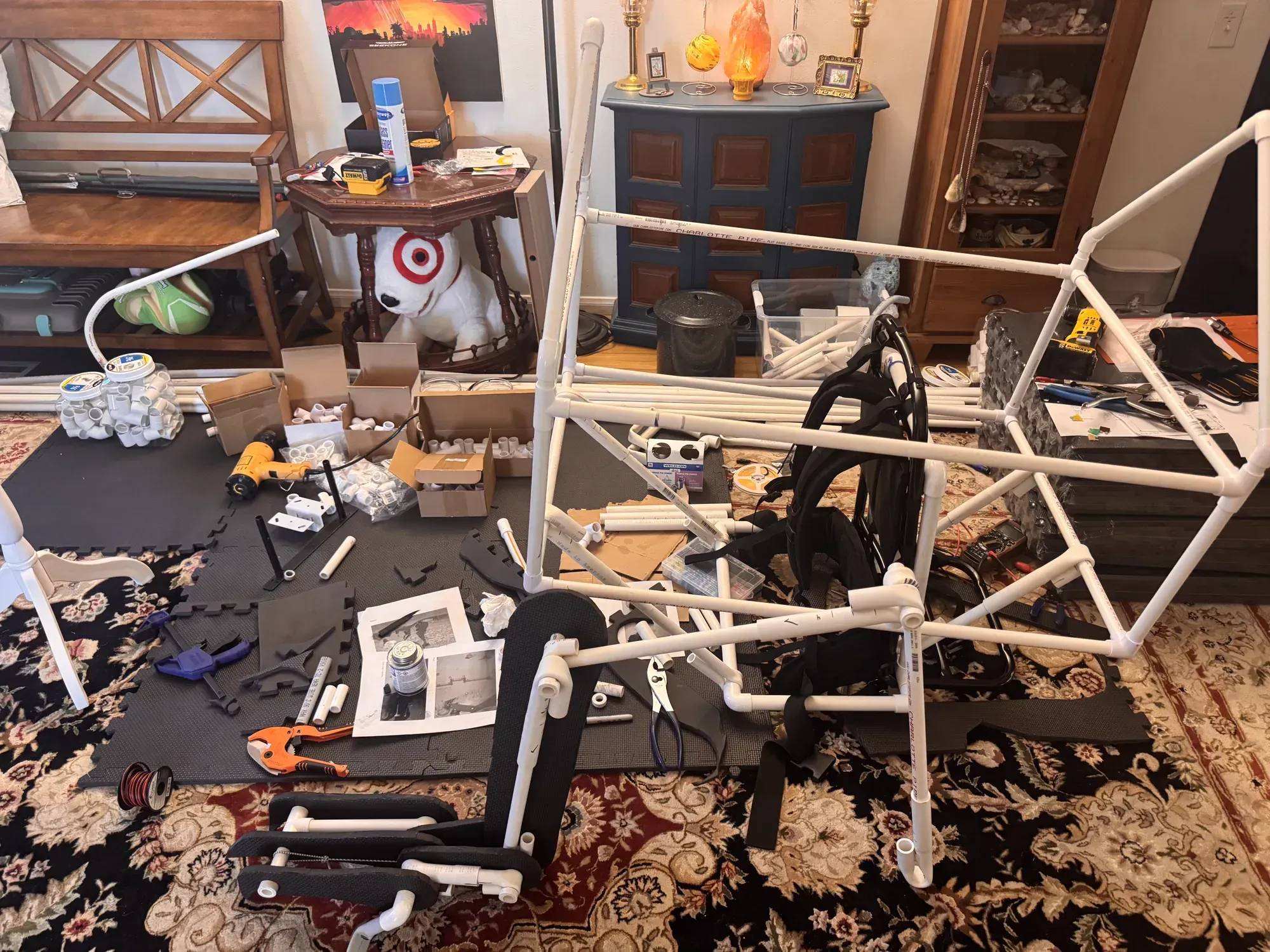 The partially glued Raptor frame, harness, tools, and PVC cement spread across the dining-room floor